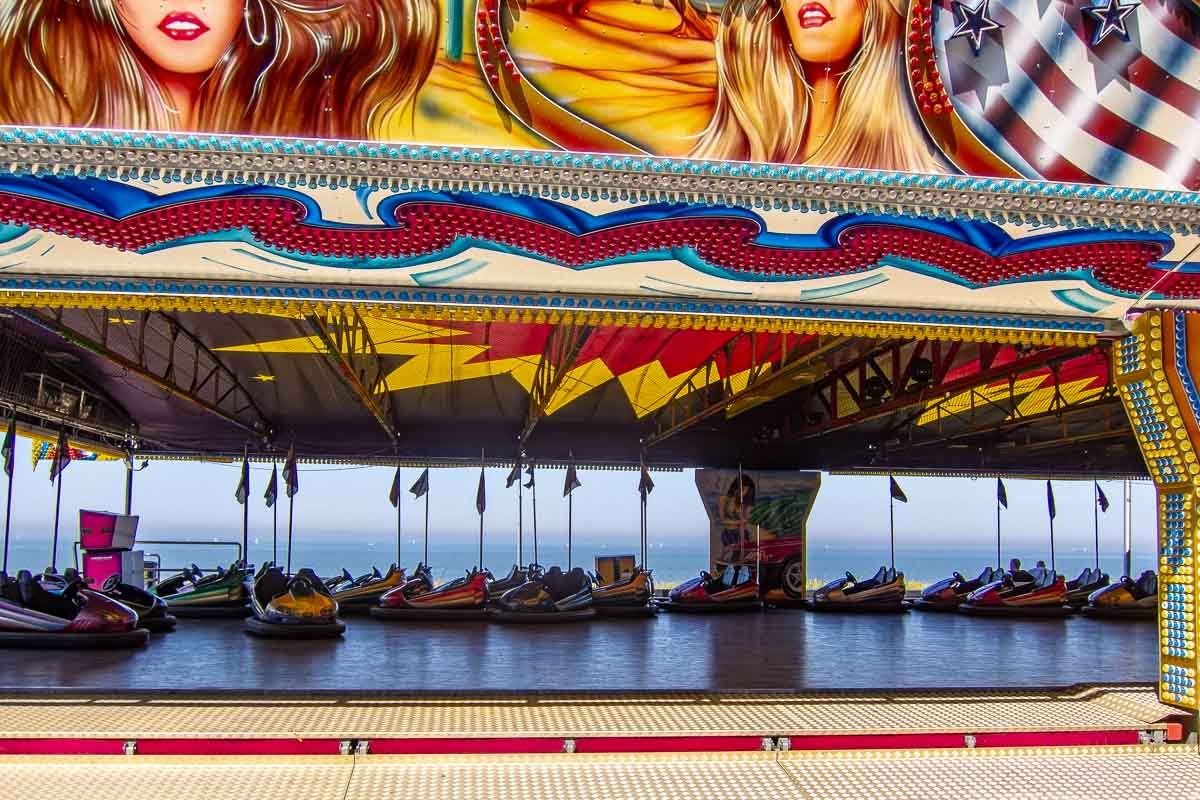 Europe H_3 Empty bumper car ride at Zandvoort beach, painted glamour figures on canopy, North Sea visible in background