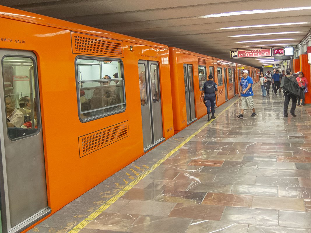 Movement_2 Bright orange metro train with doors open on a gleaming platform, no passengers yet