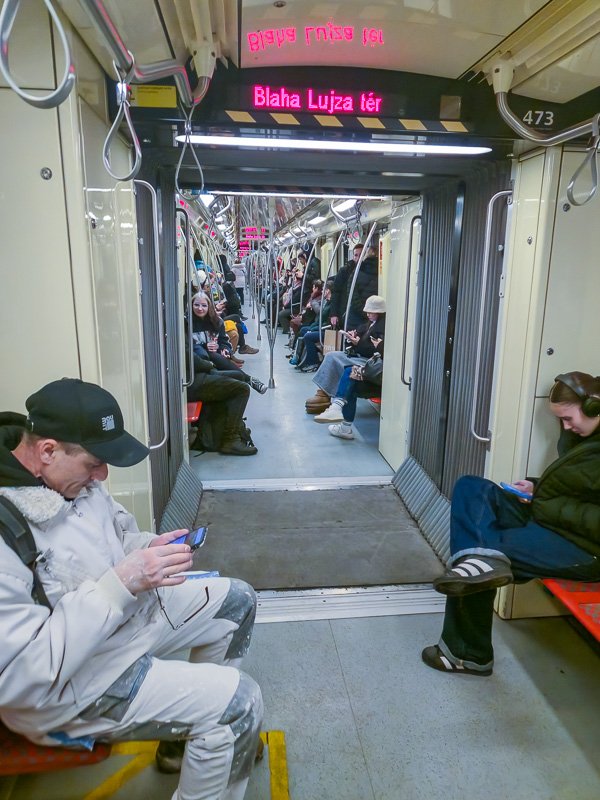Movement_8 Long metro corridor with a solitary figure seated on a bench, receding perspective