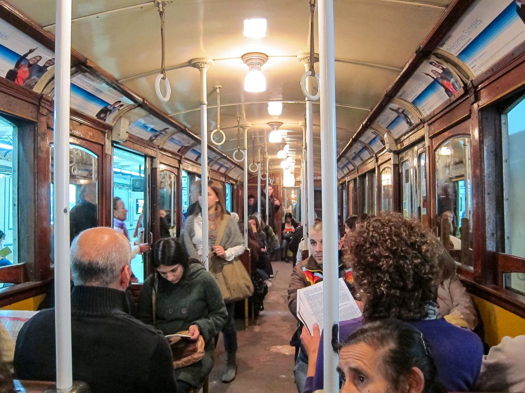 Movement_9 Interior of a vintage metro car with warm overhead light, passengers reading and sitting