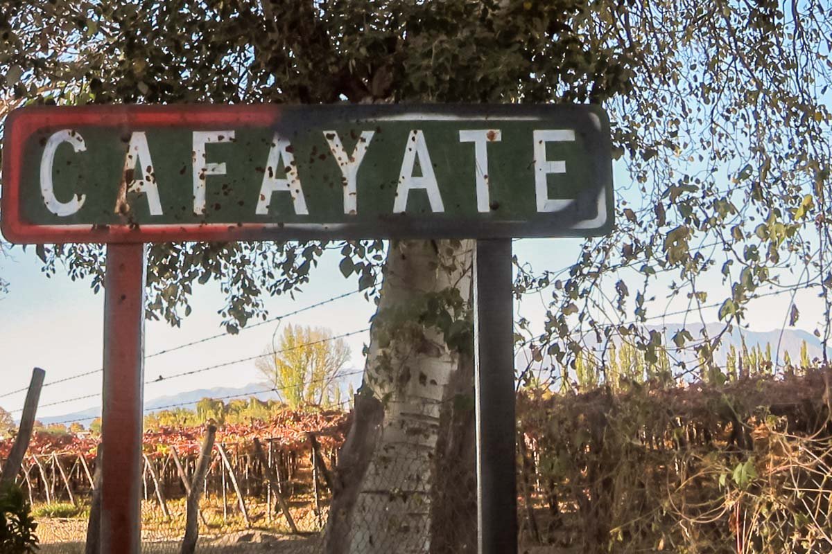Signs_4 Weathered wooden roadside sign reading CAFAYATE against a dry Argentine landscape