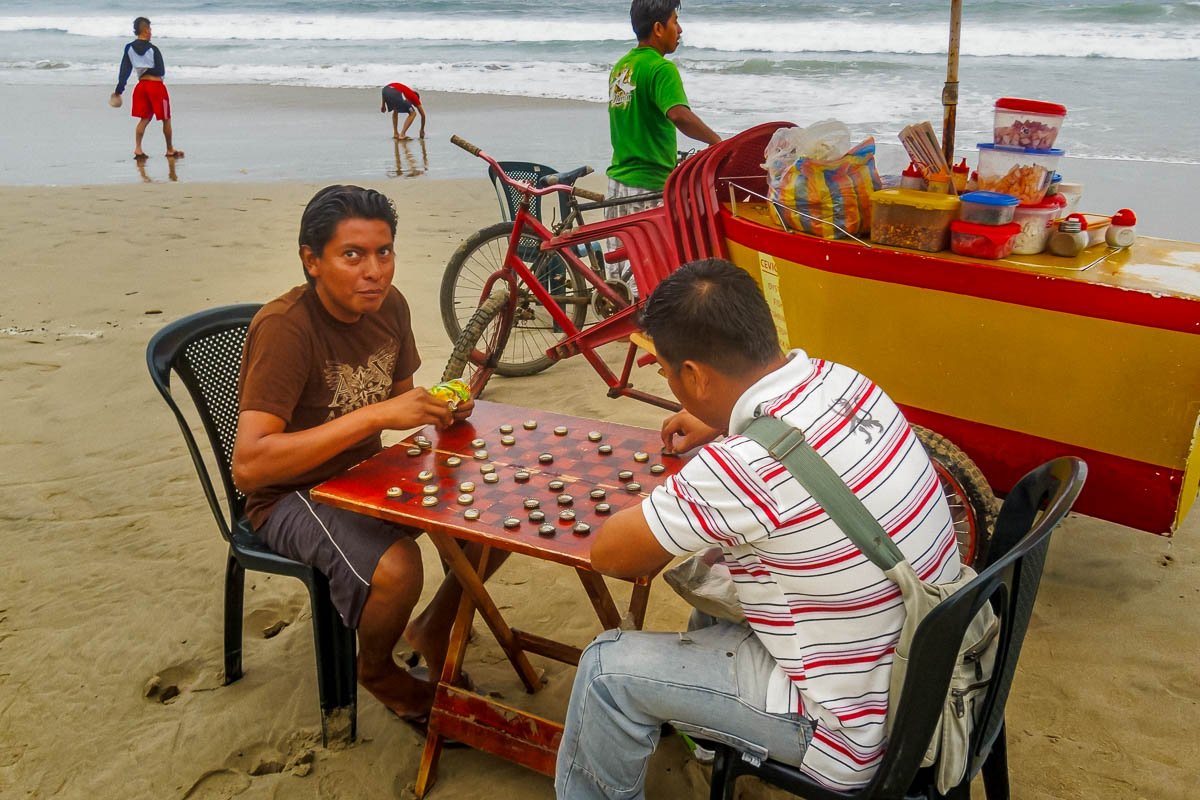 Suitcase_24 Two men playing checkers on the beach