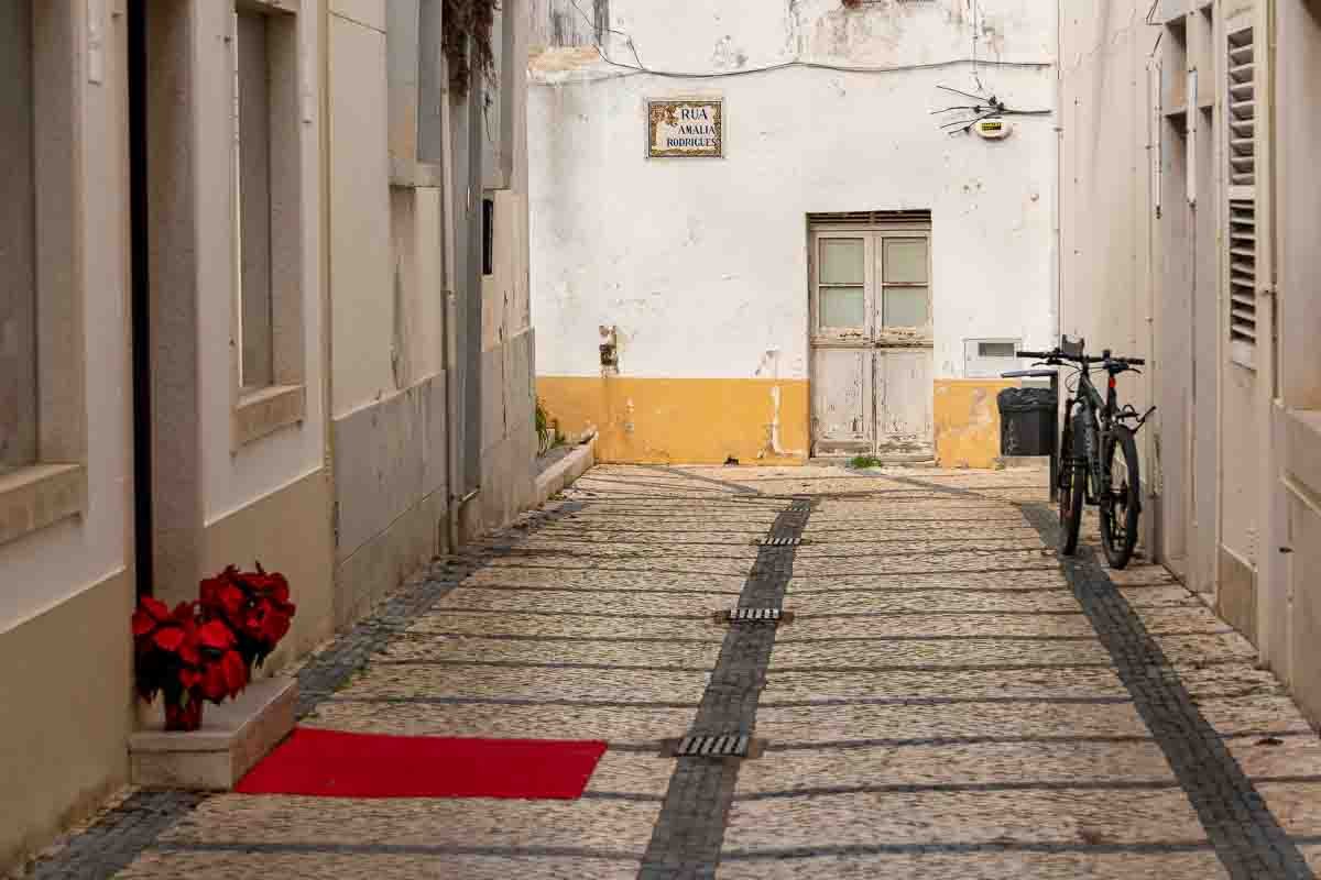 Tavira_1 Alley with red rug, flowers, and bicycle, Tavira