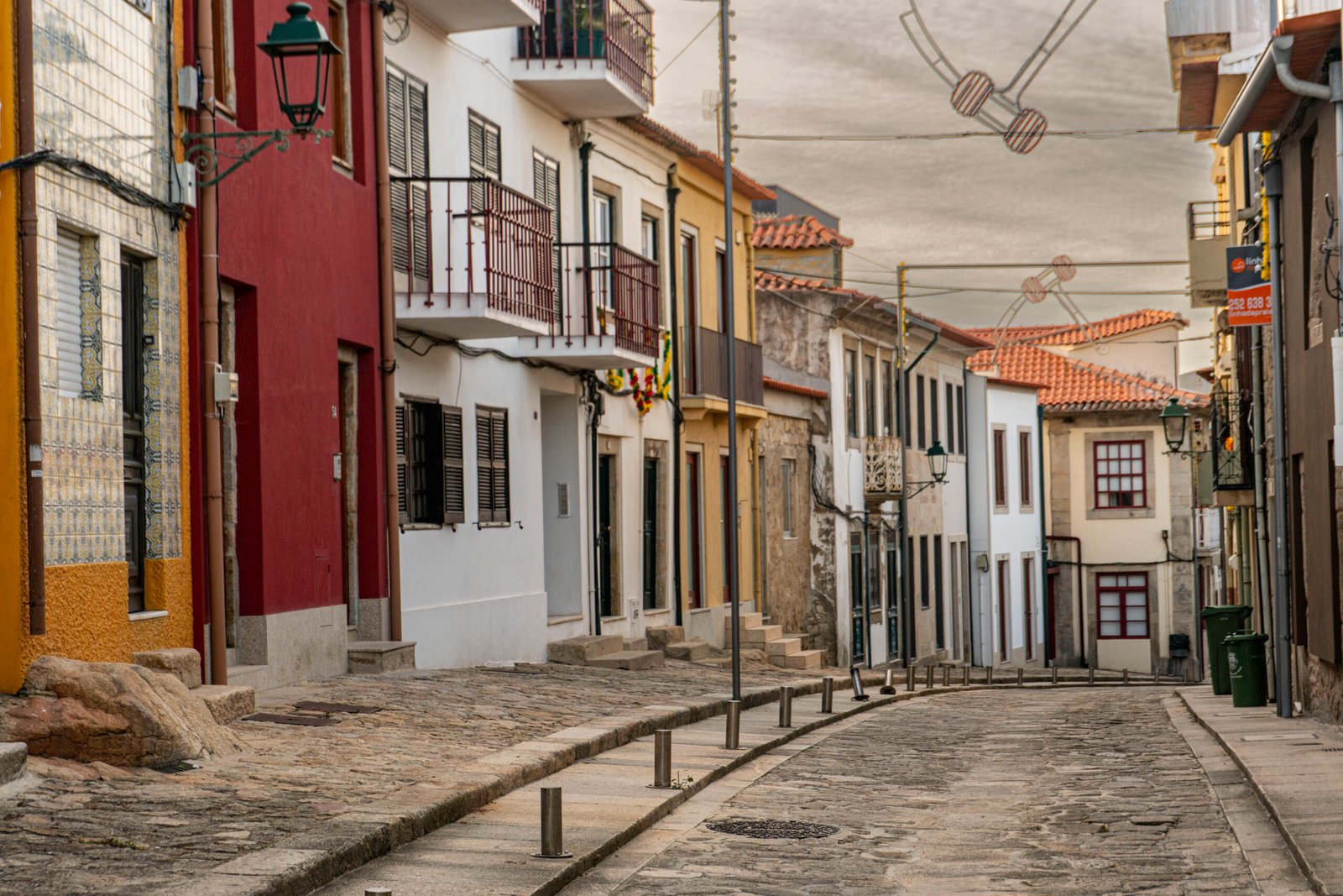 Viladoconde5 Cobblestone street with colorful houses and string lights, Vila do Conde