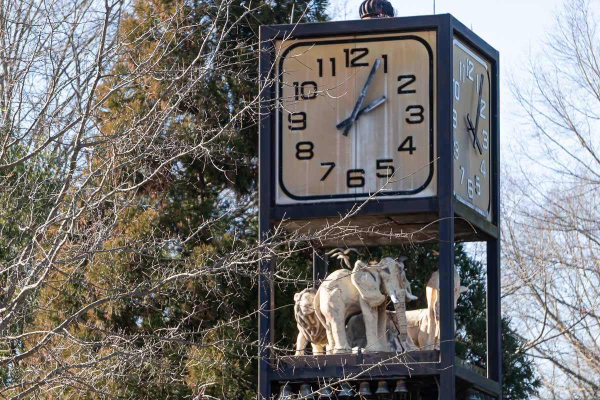 clocks_1 Ornate street clock with small decorative figurines at its base, bare winter trees behind