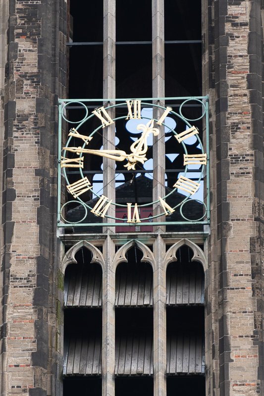 clocks_7 Large gothic clock face with ornate gold hands and black iron tracery, close architectural detail