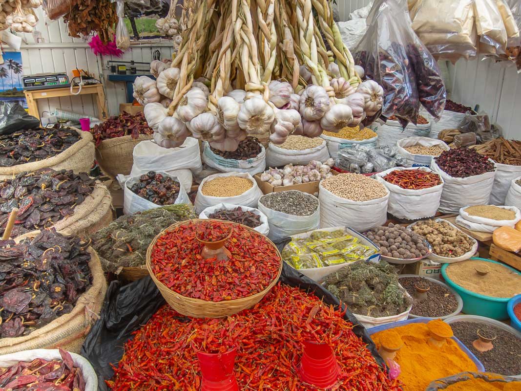 markets_9 Garlic bulbs and dried spices arranged in baskets at a market stall, close textural detail