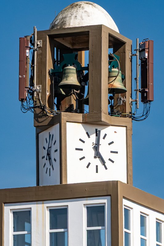 time Clock with bells against a blue sky.