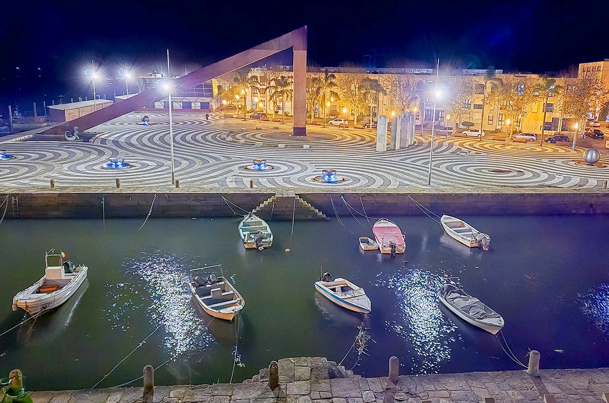 viladoconde6 Plaza and sculture monument at night, boats moored in canal, Vila do Conde