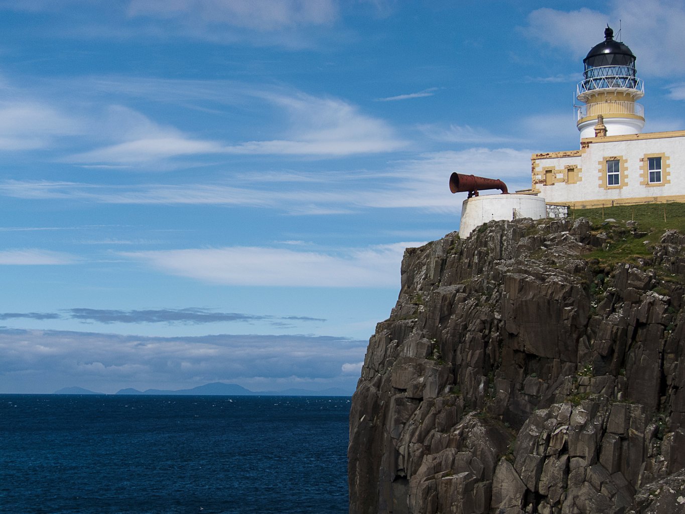 lighthouse on Isle of Sky Lighthouse on steep rocky cliff.